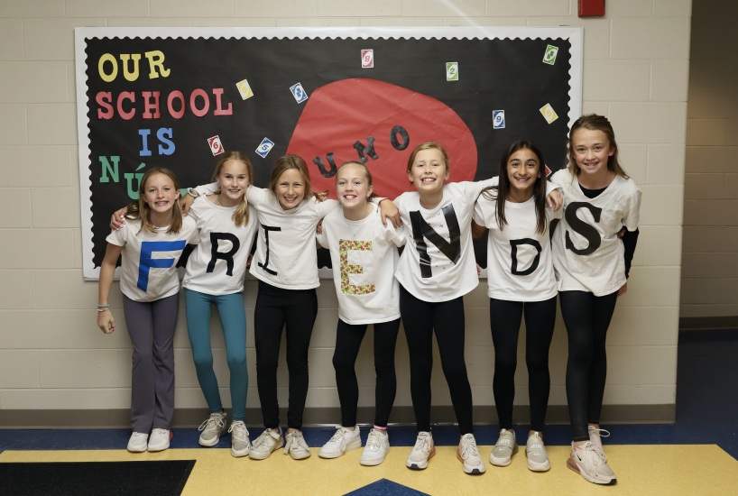 Students wear t-shirts that spell out "friends"